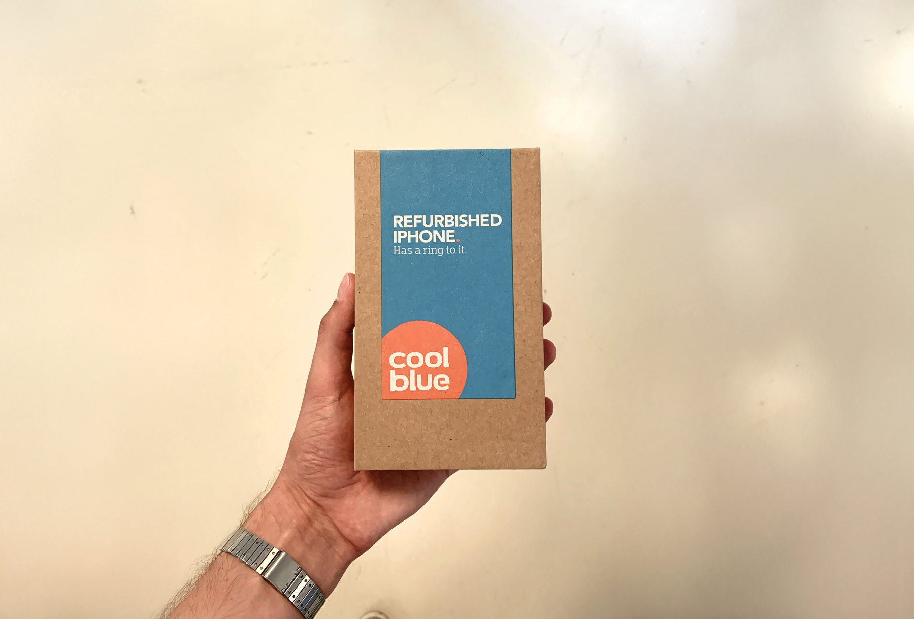 The finished Coolblue refurbished iPhone box, held in a hand